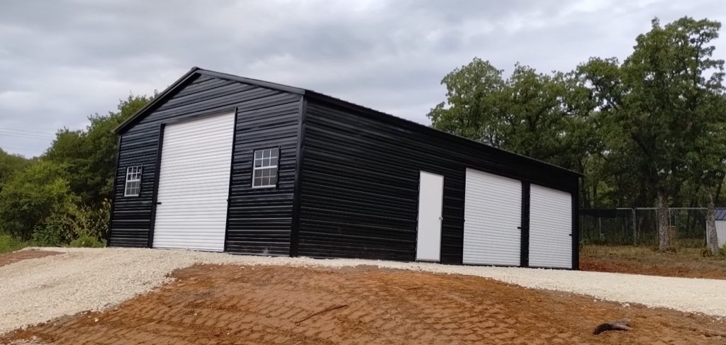 Black metal barn-style garage with white trim